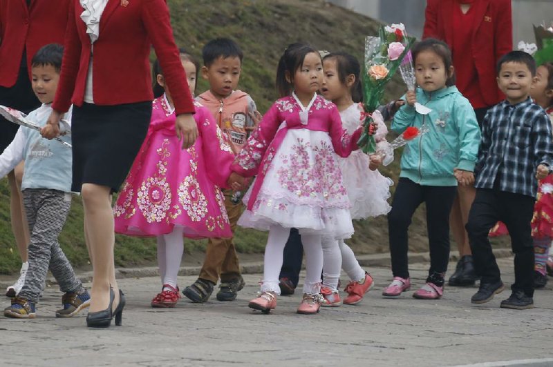 Children carry flowers Thursday in Pyongyang in preparation for celebrations marking the 70th anniversary of North Korea Workers’ Party.
