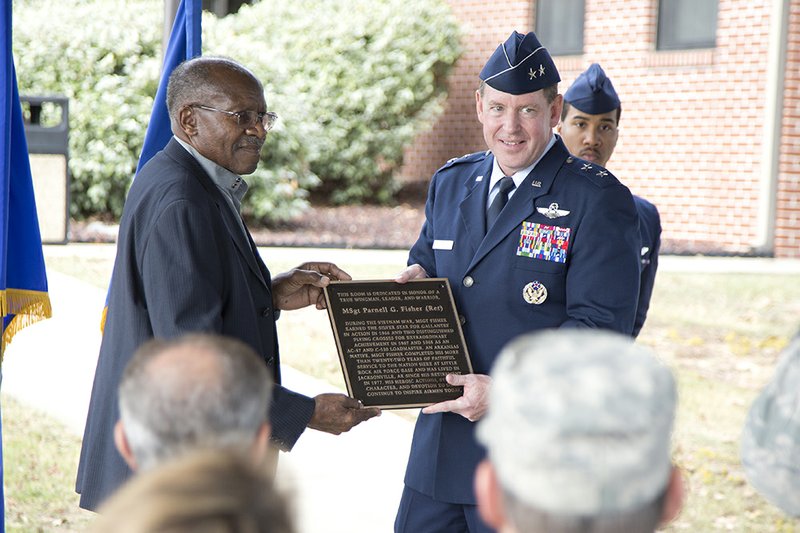 Retired U.S. Air Force Master Sgt. Parnell Fisher, left, and Maj. Gen. James Hecker hold the plaque that will be in the newly dedicated Master Sgt. Parnell Fisher Day Room at the Little Rock Air Force Base.