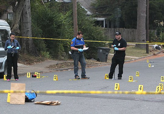 The Sentinel-Record/Richard Rasmussen SHOOTING DEATH: From left, Hot Springs police crime scene investigator Jennifer Brizo and detectives Nate Rines and Les Jessup investigate the scene of a shooting death in the 200 block of Linwood Avenue early Thursday. The victim was later identified as Steven Paul Moore, 58, who was found lying in the street after several 911 calls about shots fired.