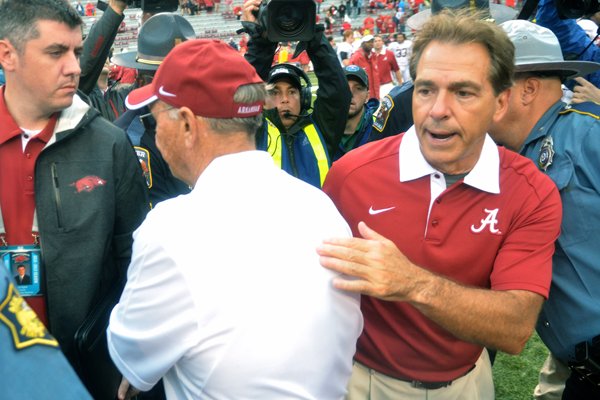 Alabama head coach Nick Saban give Arkansas coach John L. Smith a pat on the back following the Razorbacks' 52-0 loss Saturday, Sept. 15, 2012, at Razorback Stadium in Fayetteville.