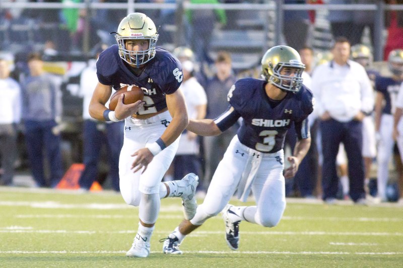 Quarterback Connor Reece of Shiloh hands off Oct. 2 to Broc Berus against Huntsville at Champions Stadium in Springdale.