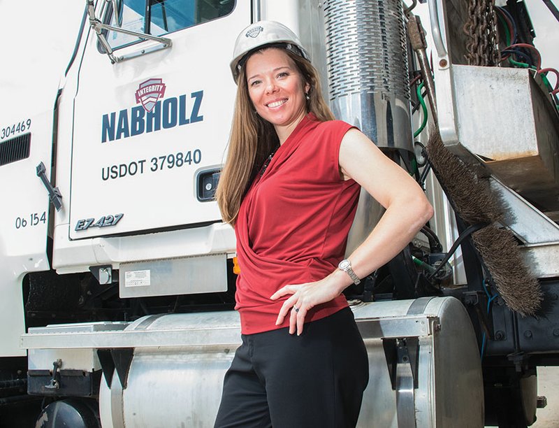 Jayme Mayo of Conway stands by a Nabholz Construction truck. Mayo, who has degrees as a physical-therapy assistant and physician’s assistant, is director of wellness for the company. In addition to working at the company’s wellness center in Conway, she finds fitness opportunities for employees when they travel to any of the 45 states in which Nabholz is licensed to do business, she said. Mayo, 40, and her husband participate in races and Iron Man competitions all over the United States.