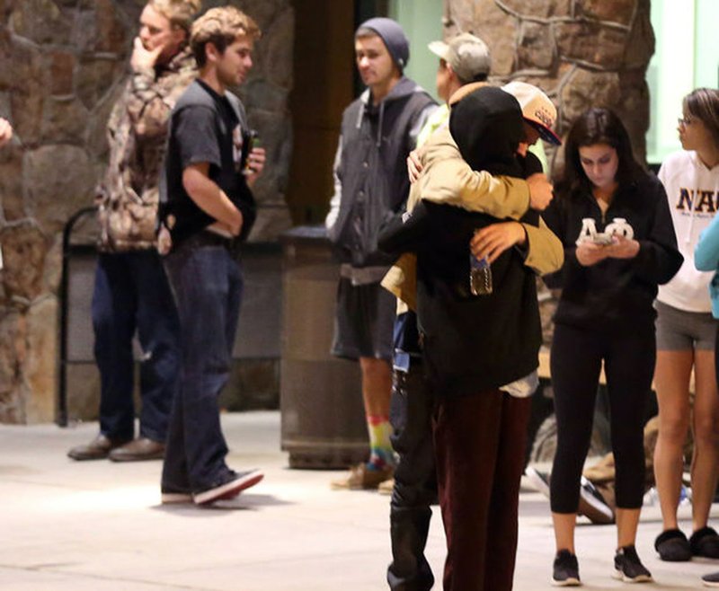 Students embrace outside a hospital emergency room in Flagstaff, Ariz., on Friday, Oct. 9, 2015, after an early morning fight between two groups of college students escalated into gunfire, leaving one person dead and three others wounded, authorities said. The shooting occurred outside a dormitory near the Northern Arizona University campus. 
