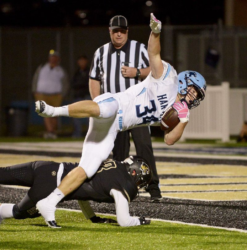 Springdale Har-Ber running back Luke Hannon dives into the end zone over Bentonville’s Aaron Estrada during the second quarter of the Wildcats’ 31-21 victory over the Tigers on Friday at Tiger Stadium in Bentonville. Hannon ran for 192 yards on 34 carries for the Wildcats. For more high school football photos, visit arkansasonline.com/galleries.