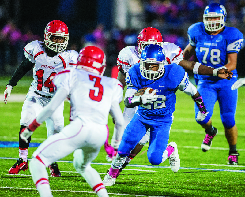 Sylvan Hills’ Deon Youngblood (22) looks for running room as several Jacksonville defenders close in during Friday night’s game. The Bears pulled away in the second half to beat the Red Devils 29-14. To see more high school photos, visit arkansasonline.com/galleries.