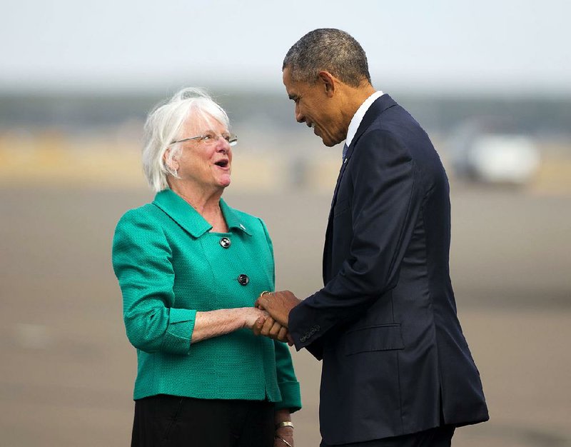 Mayor Kitty Piercy of Eugene, Ore., greets President Barack Obama as he arrives Friday for a visit to Roseburg, Ore., to meet privately with families of the victims of the mass shooting last week at Umpqua Community College. Obama’s motorcade got a mixed reception at Roseburg, with gun-rights supporters protesting his presence but others welcoming him.
