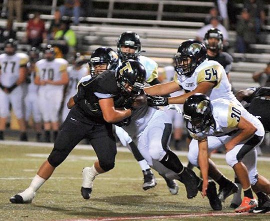 The Sentinel-Record/Mara Kuhn Several De Queen players converge on Hot Springs’ Matt Galloway in Friday night’s game on Holt Memorial Field at Reese Memorial Stadium. De Queen, which Hot Springs downed 52-12 last year en route to the 5A-South championship, took command early against the Trojans, both winless in two conference games. Hot Springs plays at Magnolia next week before an Oct. 23 home game against White Hall. 