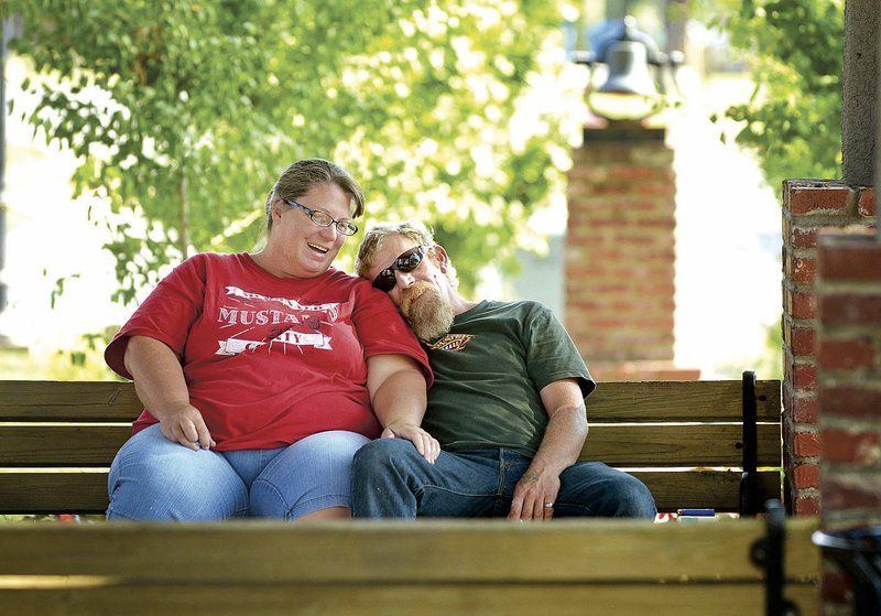 Jennifer McGonigal and husband Ben McGonigal of Rocky Comfort, Mo., relax Thursday in the gazebo at Train Station Park on South Main Street in Bentonville. The couple, originally from Bentonville, were married in the park 20 years ago, and decided to stop by and reminisce while in town visiting family. The Bentonville Public Art Advisory Committee is seeking proposals for a piece of art to be displayed in the park.