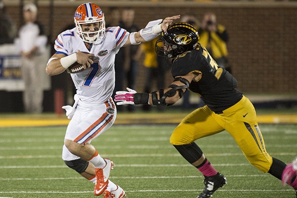 Florida quarterback Will Grier, left, pushes away from Missouri's Michael Scherer as he scrambles for a first down during the first half of an NCAA college football game, Saturday, Oct. 10 2015, in Columbia, Mo. (AP Photo/L.G. Patterson)