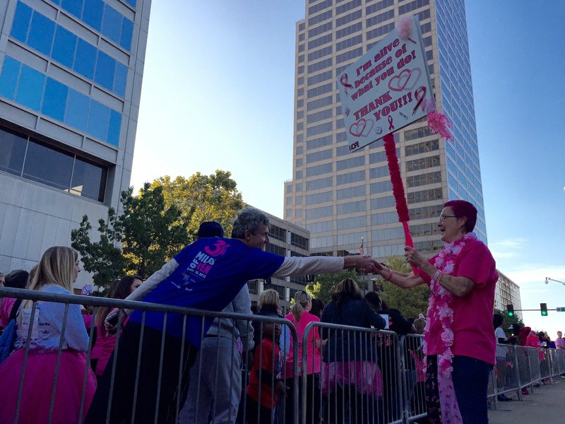 A race participant shakes the hand of 18-year breast cancer survivor Mindy Baird during the 22nd annual Susan G. Komen Race for the Cure in Little Rock on Saturday, Oct. 10, 2015. Baird said she started doing self-examinations because of her involvement in the race in 1996. Eighteen months later, she discovered a lump that was malignant. 