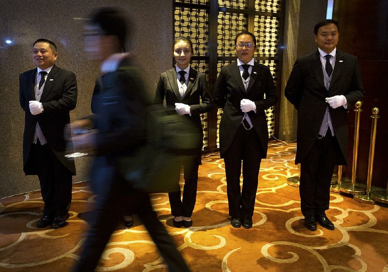 Zhang Zhejing (second from right) stands at attention with other butlers-in-training at the entrance to an event in Beijing in late September. Zhang and the others have been training at an academy in Chengdu.
