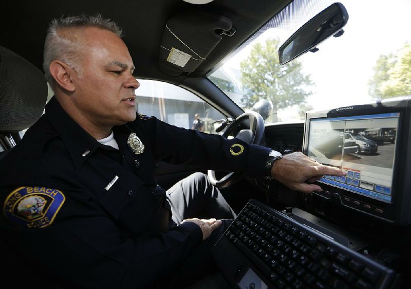 Lt. Chris Morgan of the Long Beach, Calif., Police Department shows the capabilities of his patrol car’s license plate reader, which can collect 1,600 plates an hour and feed them into a private database.