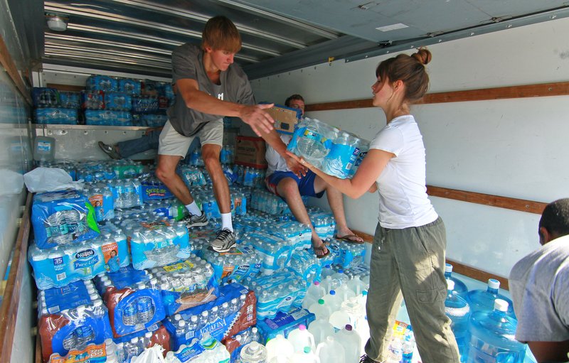 Preston Hester, left, and Johnna Godomski help unload water at Grace Episcopal Church to help flood victims in Anderson, S.C., on Thursday, Oct. 8, 2015. 