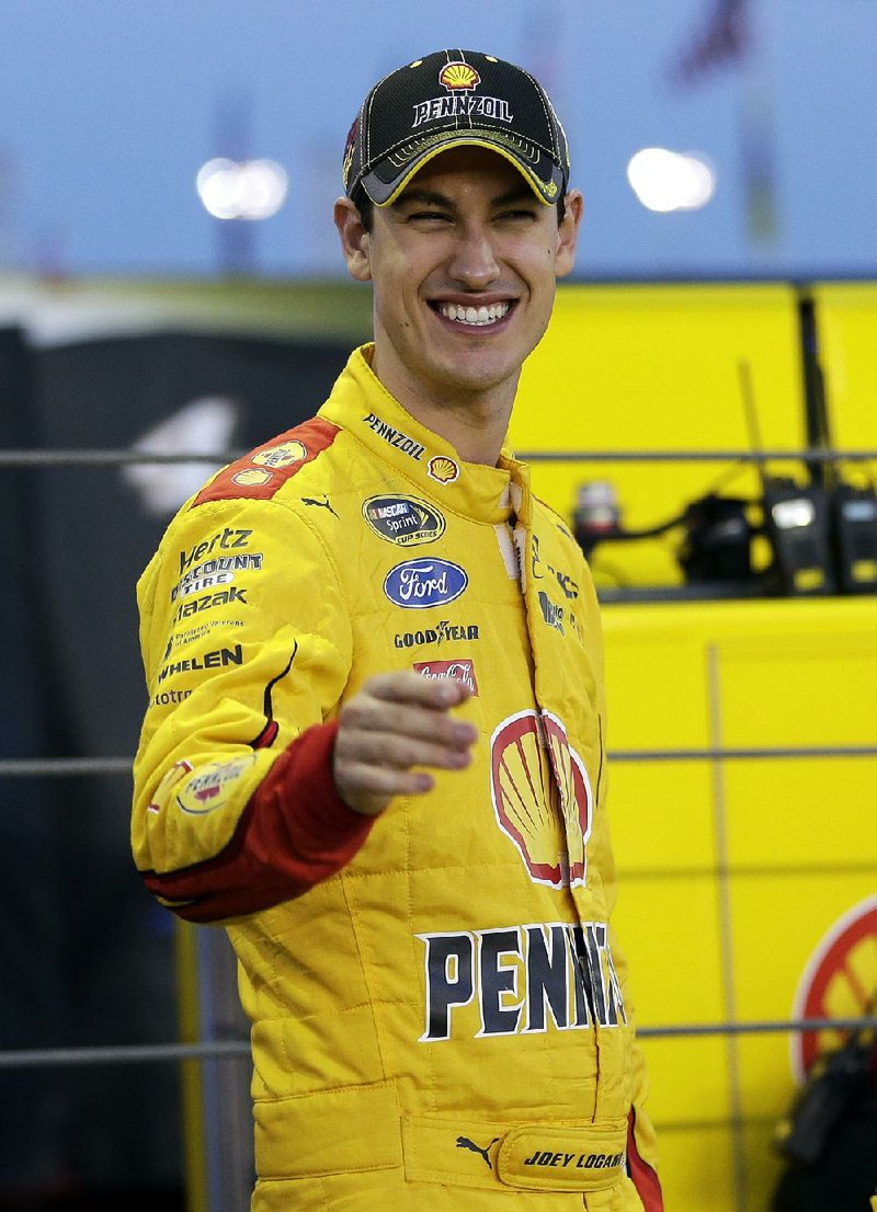 Joey Logano jokes with a crew member before qualifying for the NASCAR Sprint Cup series auto race at Charlotte Motor Speedway in Concord, N.C., Thursday, Oct. 8, 2015. 