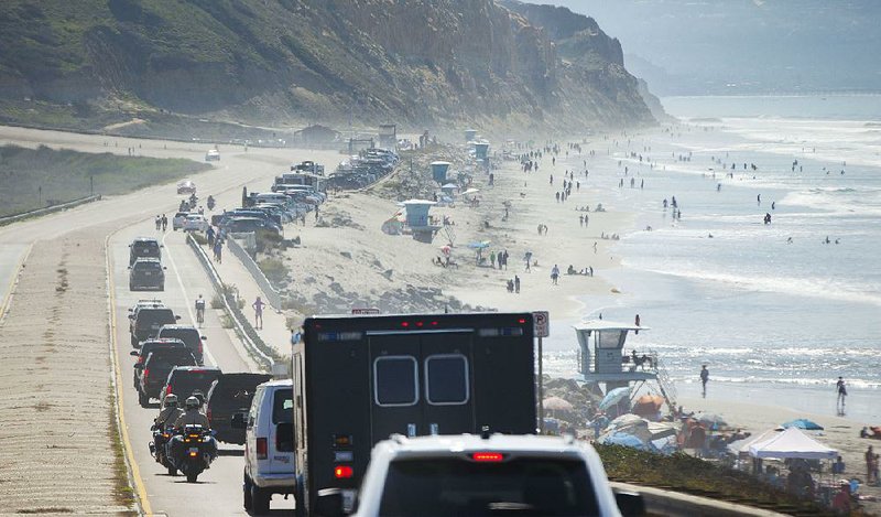 The motorcade transporting President Barack Obama drives along the Pacific Coast en route to the Torrey Pines Golf Course on Sunday in La Jolla, Calif.