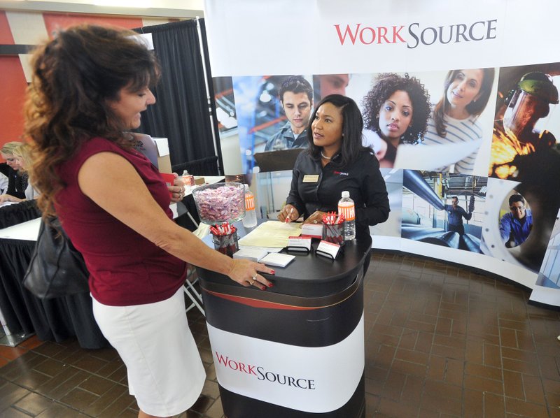 Kim Ledbetter from Goshen (left) drops off her resume with Dominique Mull with Work Source Wednesday during the job fair sponsored by the Rogers-Lowell Area Chamber of Commerce at the Frisco Station Mall in Rogers.