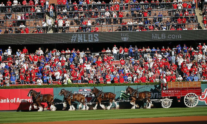 The Budweiser Clydesdales parade through Busch Stadium in St. Louis before the start of a playoff game Saturday between the St. Louis Cardinals and the Chicago Cubs. Budweiser’s brewer, Anheuser-Busch InBev, is trying to acquire rival SABMiller.
