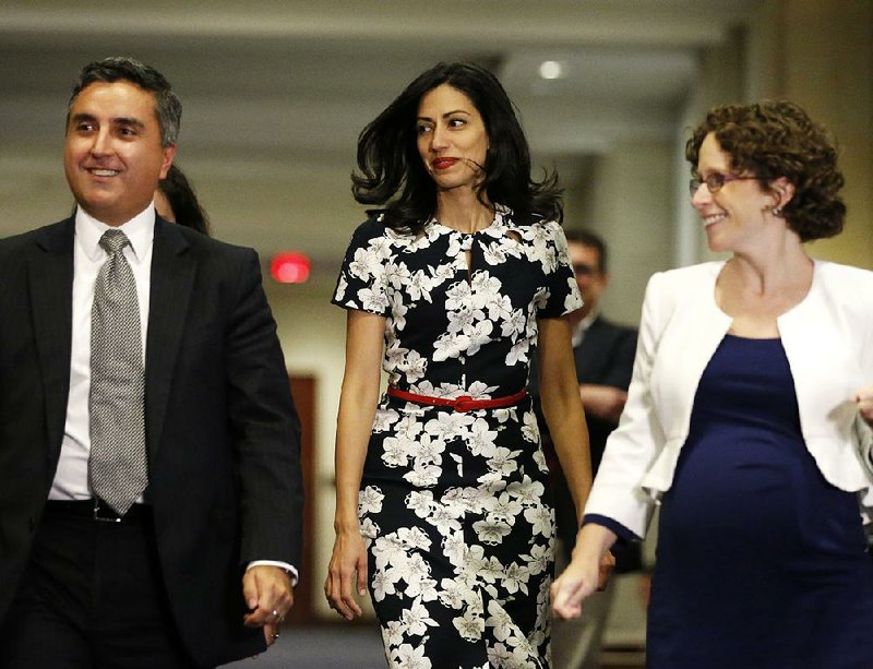 Huma Abedin (center), a longtime aide to Democratic presidential candidate Hillary Rodham Clinton, re-enters a hearing room Friday on Capitol Hill where she was testifying to the House Benghazi committee.