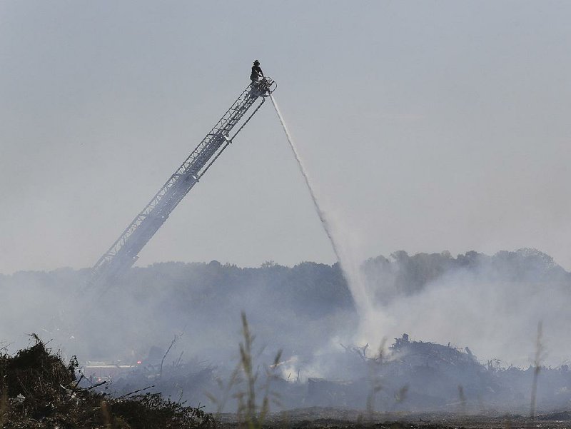 Little Rock firefighters spray water Friday morning on a compost fire at the Little Rock landfill. 