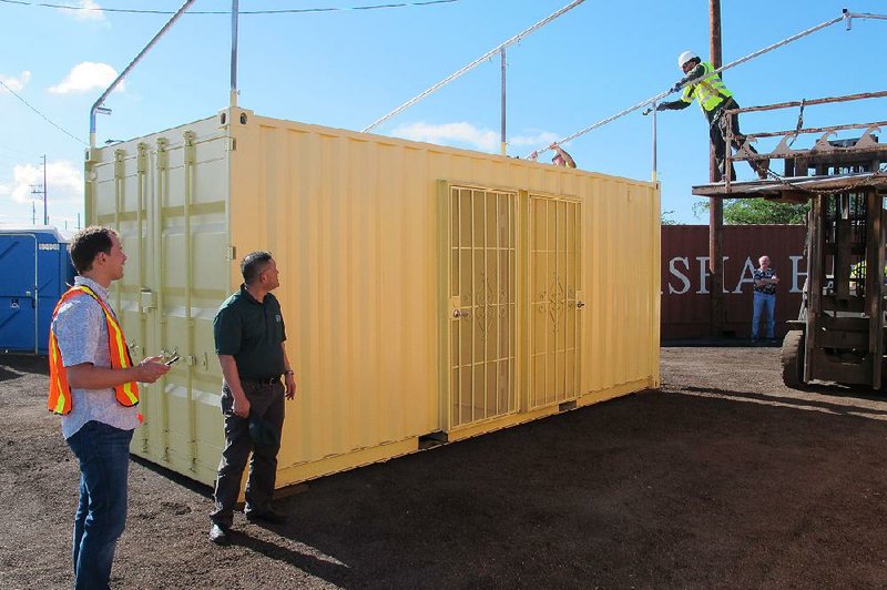 Crews in Honolulu work Friday on the awning of a shipping container that will be used as a homeless shelter. 