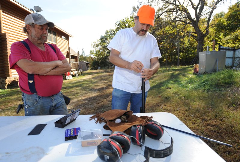 Joe Birmingham (right) and his father, Frank, demonstrate Friday with a black powder rifle at Joe Birmingham's home in Hogeye. Black powder season for deer began Saturday.