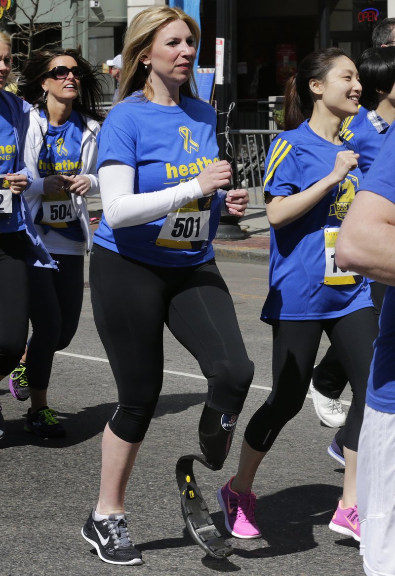 In this April 19, 2014, file photo, Boston Marathon bombing survivor Heather Abbott, center, dashes from the start line on her running blade during the Tribute Run during Boston Marathon weekend in Boston. The foundation that Abbott created will donate its first custom-made artificial limb to Hillary Cohen, of Walpole, Mass., who will have it fitted on Monday, Oct. 19, 2015. Cohen’s right leg was amputated below the knee in 2014 because of complications from neurofibromatosis. Abbott had her own left leg amputated below the knee after sustaining severe injuries in the 2013 terrorist attack near the marathon finish line. 