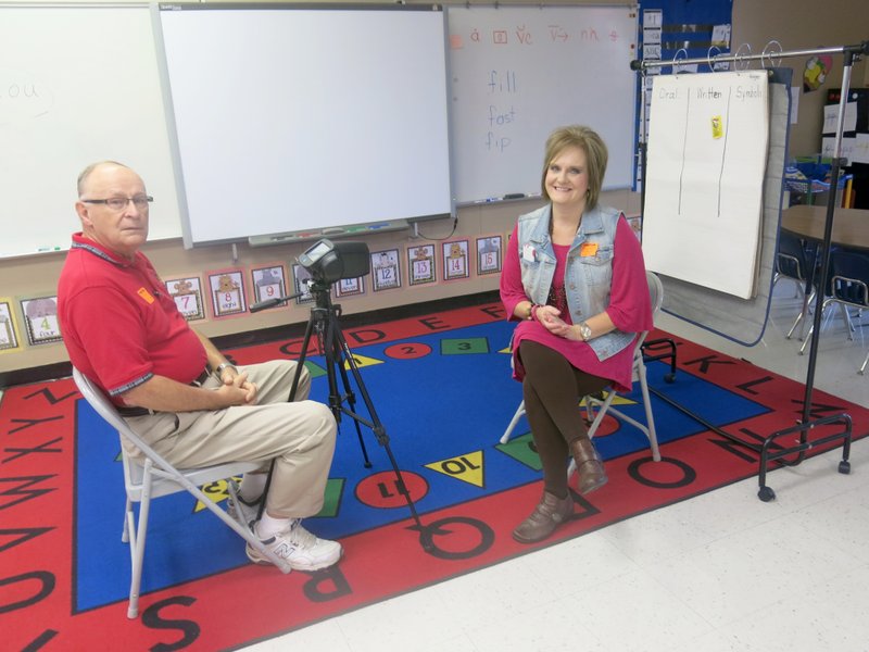 Photo by Susan Holland Ken Swanson, of Bella Vista, past district Lions Club president, and Reta Wilkins, a member of the Gravette Lions Club and manager of Roberts-Philpott Eye Associates, waited in a classroom at Glenn Duffy Elementary School for kindergarten students to come in for eye testing. Swanson and Wilkins gave the tests as part of the Lions&#8217; sight conservation program during Worldwide Week of Service in Sight, Oct. 4-10.
