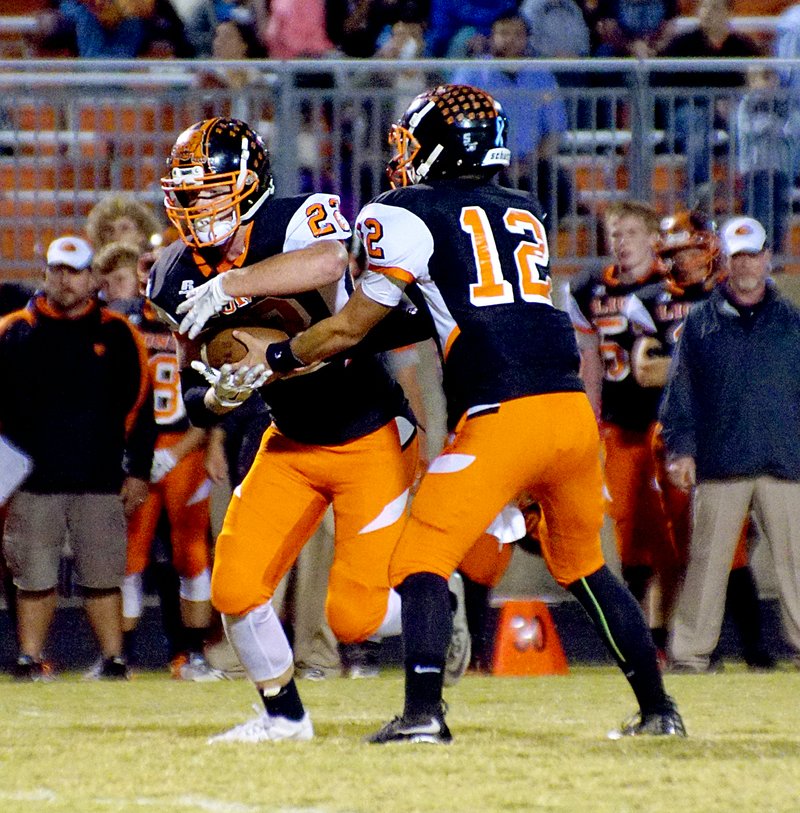 Photo by Randy Moll Jackson Soule&#8217;, Gravette senior, takes the handoff from Gravette quarterback, Bryce Moorman, also a senior, during play between Gravette and Berryville in Gravette on Friday, Oct. 16, 2015.