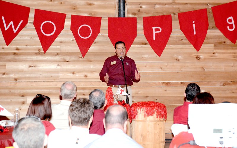 Jeff Della Rosa/Special to the Herald-Leader Emcee Randy Torres speaks while standing in front of a red and white &#8216;Woo Pig&#8217; banner. Torres wore a Texas A&amp;M shirt to the event with the Razboracks theme. Several attendees gave Torres a hard time for his support for Texas A&amp;M.
