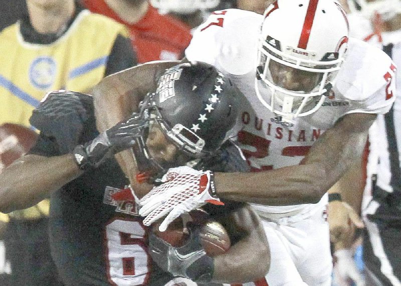 Arkansas State running back Warren Wand (6) tries to escape Louisiana-Lafayette’s T.J. Worthy in the second quarter of the Red Wolves’ 37-27 victory Tuesday night in Jonesboro.