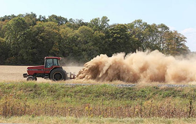 A farmer stirs up a cloud of dust Thursday along U.S. 165 near Keo. The state’s topsoil now is the driest on record for any October.