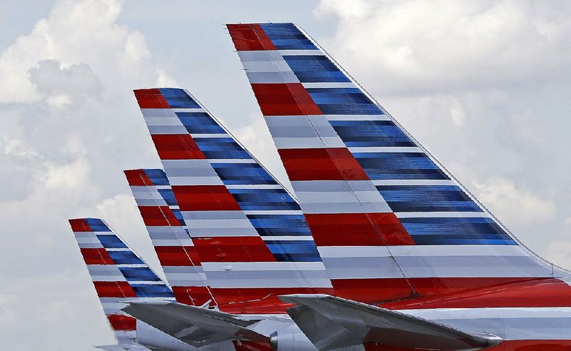 Four American Airlines planes sit at Miami International Airport. A huge drop in the cost of fuel contributed to the airline’s profit surge in the third quarter.
