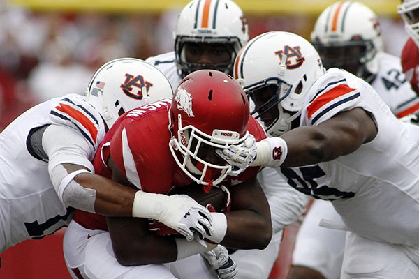 Arkansas' Rawleigh Williams III, center, attempts to break through the grip of the Auburn's defense during an NCAA college football game Saturday, Oct. 24, 2015, in Fayetteville, Ark. (AP Photo/Samantha Baker)