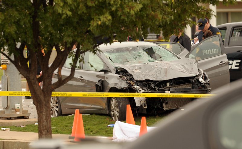 Police investigate a damaged car after the vehicle crashed into a crowd of spectators during the Oklahoma State University homecoming parade, causing multiple injuries, on Saturday, Oct. 24, 2015 in Stillwater, Oka.