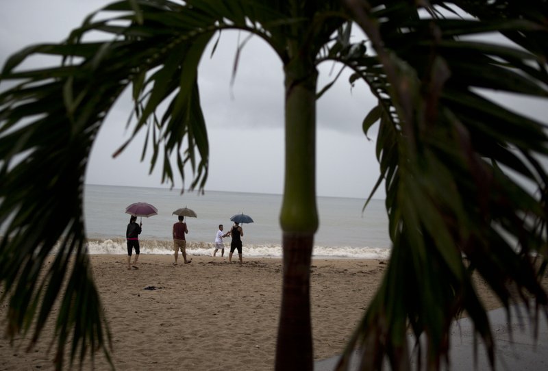 People walk along the beach under a steady rain as they await the arrival of Hurricane Patricia in Puerto Vallarta, Mexico, Friday, Oct. 23, 2015. The storm was homing in on a Pacific coastline dotted with sleepy fishing villages and gleaming resorts, including the popular beach city of Puerto Vallarta and the port of Manzanillo. 