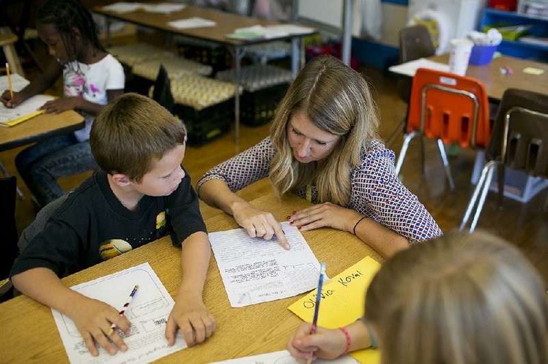 Third-grade teacher Allison Pitt helps a student last month at West Broad Elementary School in Columbus, Ohio. Students spend about 20 to 25 hours per school year taking standardized tests, according to a study released Saturday by the Council of the Great City Schools.