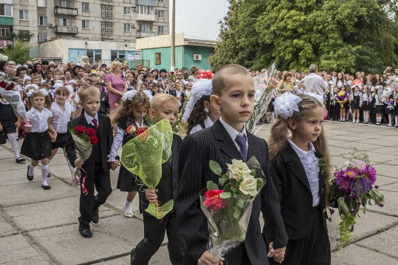 Students take part in a welcoming ceremony on the first day of school Sept. 1 in Mariupol, Ukraine, where a weird kind of normalcy has taken hold months after the city was on the front lines of war.