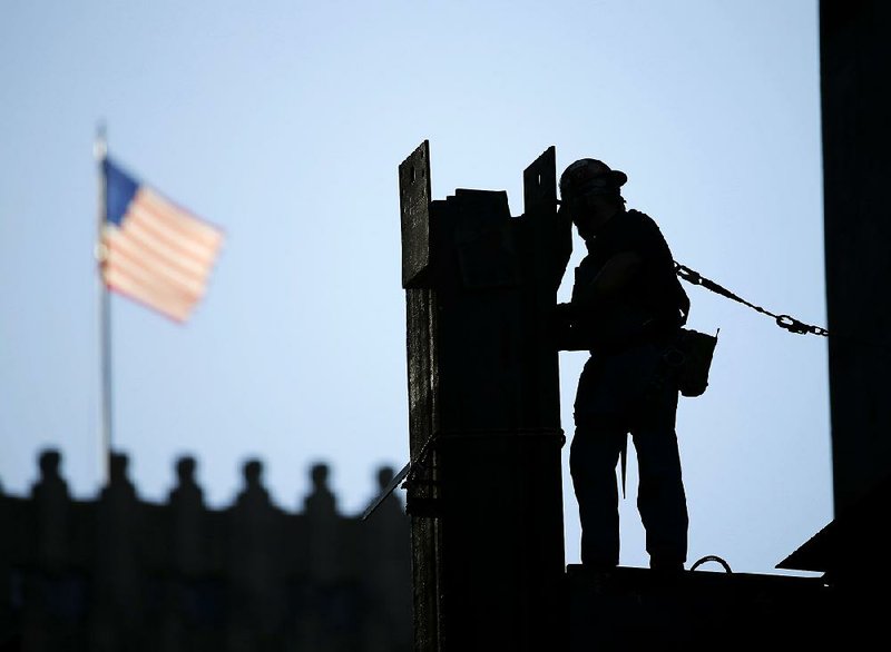 An ironworker stands at the new Comcast Innovation and Technology Center under construction in Philadelphia in September. Business economists surveyed between Sept. 21 and Oct. 6 said they expect modest economic growth in the U.S. for the rest of the year.
