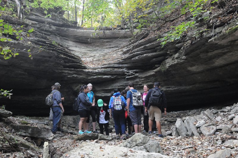 Tiffany Harris (second from right), an outdoor education teacher at Rogers New Technology High School, hikes with students along a bluff shelter Oct. 7 near Gateway. Students from Rogers New Tech and Rogers High School hiked and shot clay targets during a field trip.