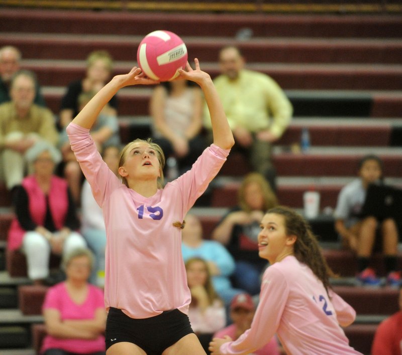Fayetteville High’s Ella May Powell (15) sets up the ball for teammate Faith Waitsman (12) during their game against Springdale High School Oct. 13 in Springdale.