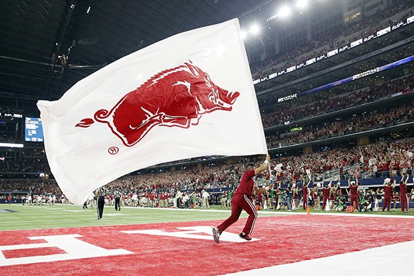 A member of the Arkansas spirit team runs through the end zone carrying a school flag during an NCAA college football game against Texas A&M Saturday Sept. 26, 2015, in Arlington, Texas. (AP Photo/Tony Gutierrez)