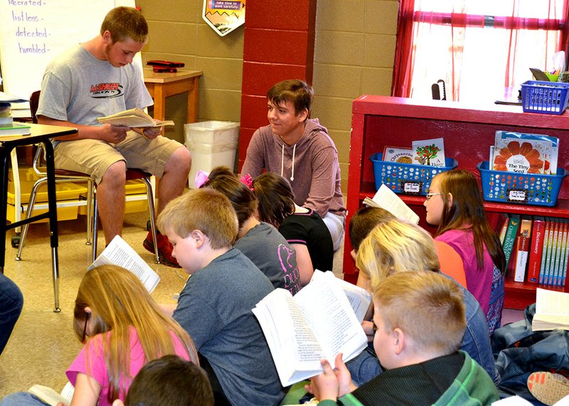 Pangburn High School junior Logan Wolfe, left, and freshman Timothy Bloxom read to Susan Ramsey’s third-grade Language Arts class as part of the Hero Within club.