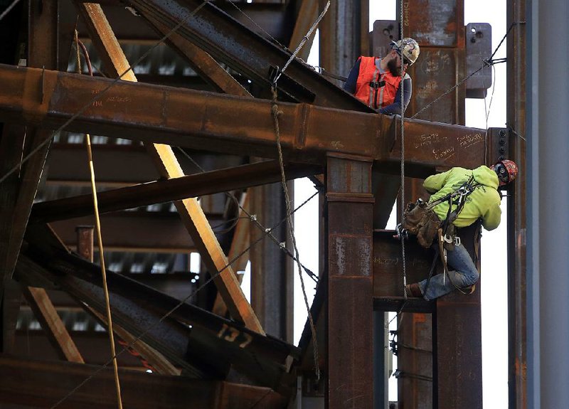 Iron workers scale the new Comcast Innovation Technology Center in Philadelphia last week. The economy grew at a tepid annual rate of 1.5 percent in the July-September quarter, the Commerce Department said Thursday.