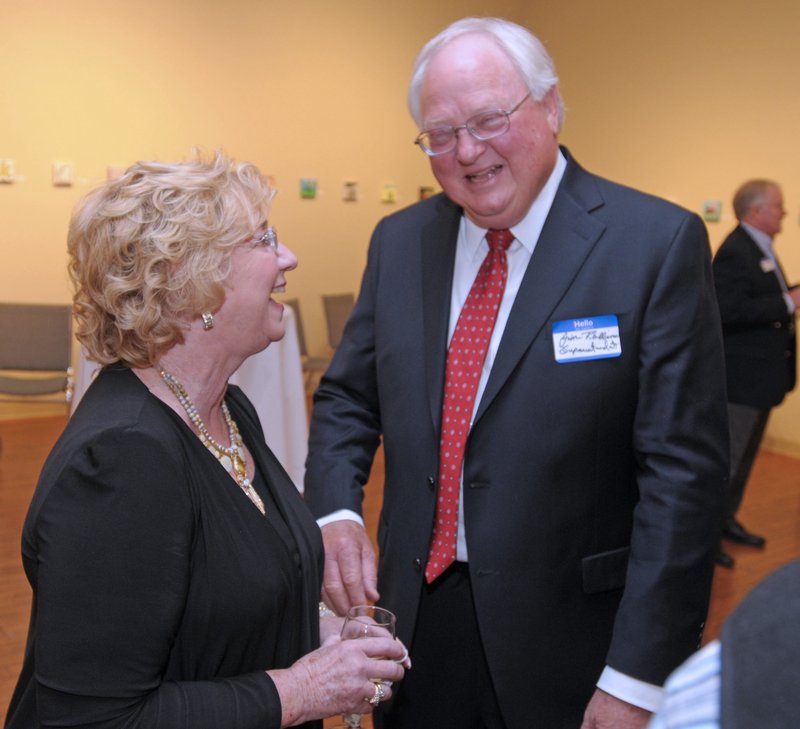 Marsha Jones, former associate superintendent of Springdale Public Schools (left), speaks Thursday with Jim Rollins, superintendent, before the start of the ceremony. Jones was honored during the ceremony.
