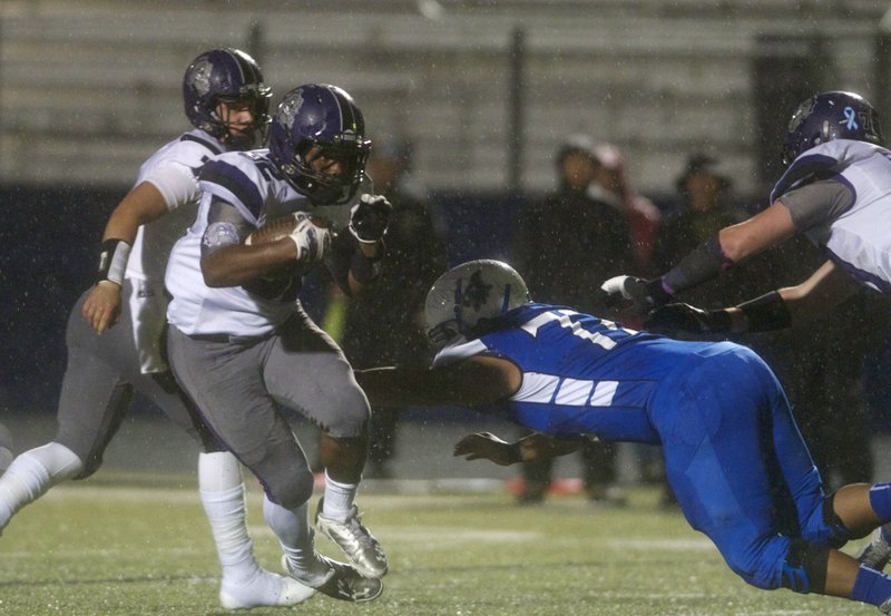 Javontae Smith, Fayetteville running back, avoids a tackle by Rogers High defensive tackle Luis Salas during the first half of Friday’s game in Rogers.