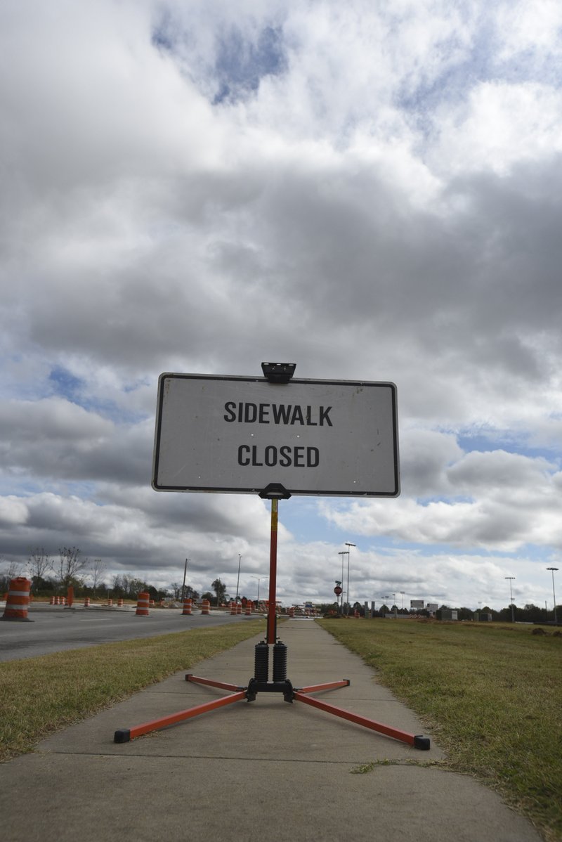 A sidewalk under construction is closed Friday at the intersection of Don Tyson Parkway and Hylton Road in Springdale. The City Council has given out several waivers in 2015 for residents, allowing them to not build sidewalks when doing work on their homes.