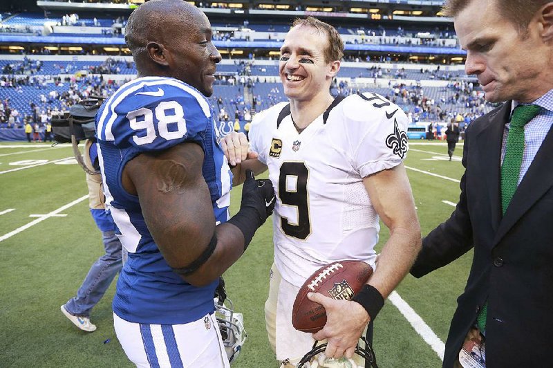 New Orleans Saints quarterback Drew Brees (9) greets Indianapolis Colts outside linebacker Robert Mathis (98) following an NFL football game in Indianapolis, Sunday, Oct. 25, 2015.