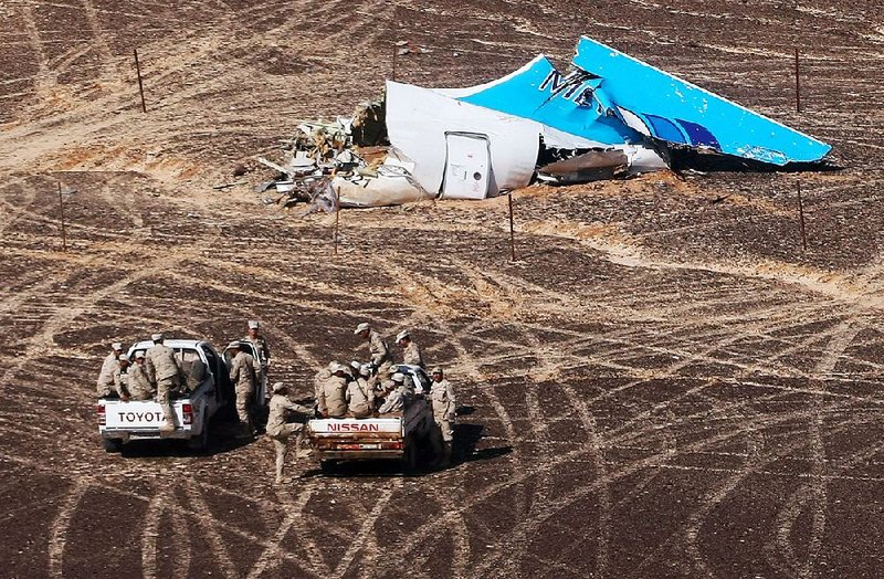 In this photo made available Monday, and provided by Russian Emergency Situations Ministry, Egyptian soldiers approach wreckage of a passenger jet that crashed Saturday in Hassana, Egypt.