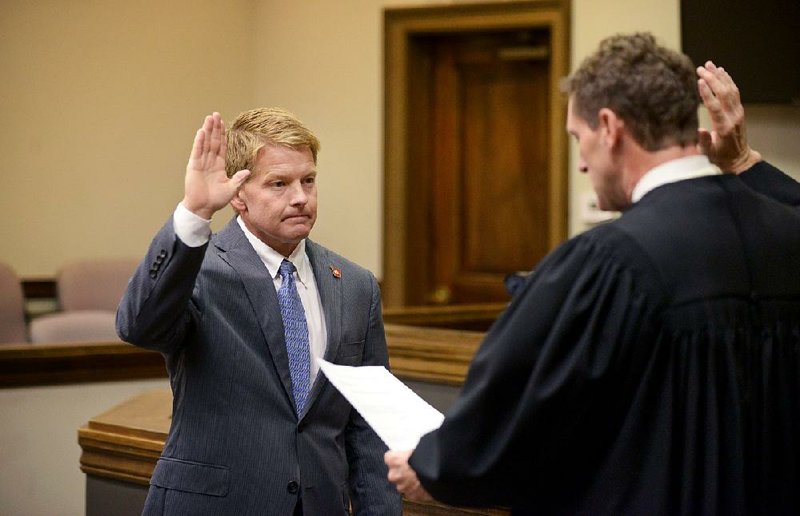 Jason Barrett (left), sworn in as special prosecutor, stands before Benton County Circuit Judge Brad Karren on Monday in the Benton County Courthouse Annex in Bentonville. Barrett has been appointed as special prosecutor in the case against Benton County Sheriff Kelley Cradduck.