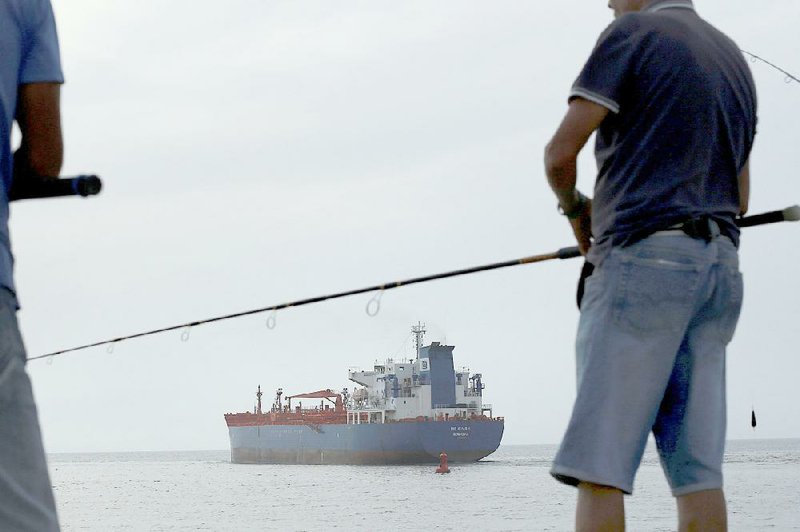The MS Simon tanker sails past fishermen at the Port of Havana in June. Congressional leaders were urged Tuesday to allow Cuba to finance the purchase of U.S. commodities in a letter from Gov. Asa Hutchinson. 